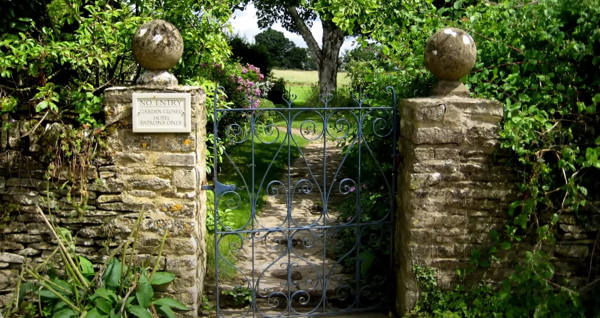 Professional Garden Maintenance and Landscape Design Traditional garden gate with beautiful landscaping and professional garden maintenance